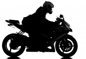 Silhouette of a motorcycle racer with helmet on the white background.